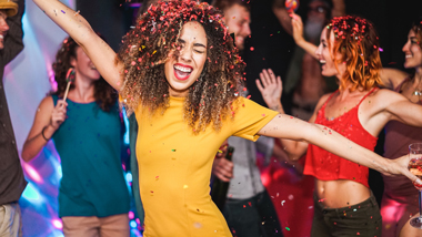 dancing happy girl in yellow dress at disco